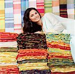 Portrait of a young woman lying on a stack of clothes