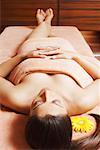 Vue grand angle d'une jeune femme allongée sur une table de massage