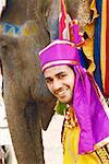 Porträt eines jungen Mannes stehend mit einem Elefanten