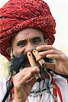 Porträt eines Reifen Mannes spielen zwei Flöten mit seiner Nase, Jaipur, Rajasthan, Indien