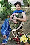 Portrait of a mature woman sitting on a chair and holding a bunch of flowers