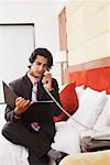 Businessman talking on the telephone and reading a file