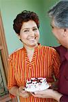 Close-up of a mature couple holding a birthday cake