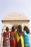 Rear view of four women standing in front of a monument, India Gate, New Delhi, India