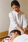 Jeune femme à obtenir un massage des épaules d'un massothérapeute