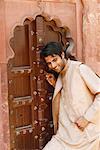Gros plan d'un jeune homme debout devant une porte en bois, Fort d'Agra, Agra, Uttar Pradesh, Inde