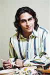 Portrait of a young man sitting at the dining table and smiling