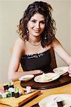 Portrait of a young woman sitting at the dining table and smiling