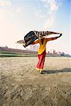 Rear view of a young woman holding her stole on the riverbank, Taj Mahal, Agra, Uttar Pradesh, India