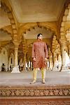 Vue d'angle faible d'un jeune homme debout et à la recherche sur le côté, Fort d'Agra, Agra, Uttar Pradesh, Inde