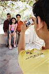 Rear view of a boy taking a picture of his grandparents and his sister