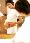Femme enceinte en regardant son ventre en miroir