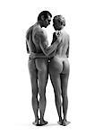 Nude man and woman standing with arms around each other, rear view, b&w