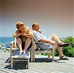 Mature couple sitting in deckchairs outside