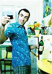 Mann in Küche, Flasche Wein, halten Anhebung seiner Glas, Porträt.