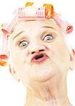 Femme âgée plissement des lèvres et portant des bigoudis, portrait, gros plan