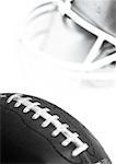 Football and helmet, close-up, b&w.