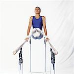 Young male gymnast on parallel bars, front view