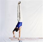 Male gymnast performing routine on parallel bars