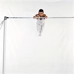 Gymnaste masculin se balançant sur la barre horizontale