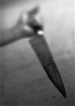 Hand holding kitchen knife, blurred, b&w
