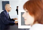 People working in office, businessman using computer, side view