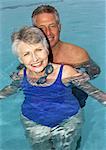 Couple d'âge mûr en piscine, sourire, portrait