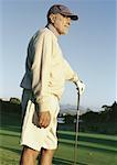 Mature man leaning on golf club