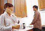 Woman smiling at man washing dishes.