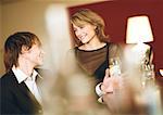 Young man and woman at bar, smiling