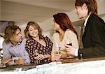 Young men and women drinking at bar