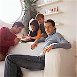 Mother sitting in front of family, playing in background