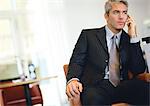 Businessman sitting, talking on cell phone