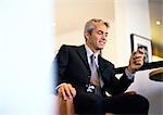 Businessman sitting holding cell phone