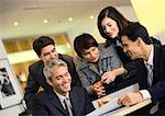 People grouped together, one man pointing at document