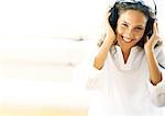 Woman listening to headphones, smiling