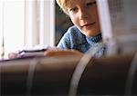 Young boy looking at video game, close up, computer and desk blurred in foreground