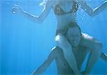 Man carrying woman on shoulders, underwater view