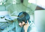 Man using cell phone, seen through glass pane