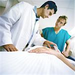 Doctors standing over patient