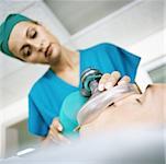 Female doctor holding oxygen mask over patient's face