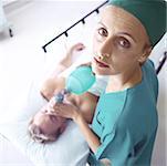 Female doctor holding oxygen mask over patient's face, high angle view