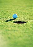 Golf ball near hole, close-up