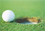 Golf ball at edge of hole, close-up