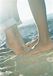 Couple d'adolescents, jeune fille debout sur la pointe des pieds, partie inférieure des jambes et des pieds en gros plan