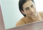 Man applying shaving cream in mirror