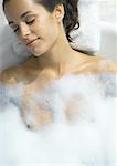 Femme couchée dans le bain à bulles