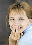 Girl covering mouth looking at camera, smiling, portrait, close-up