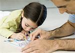 Girl coloring with father