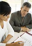 Businessman and assistant looking at agenda together